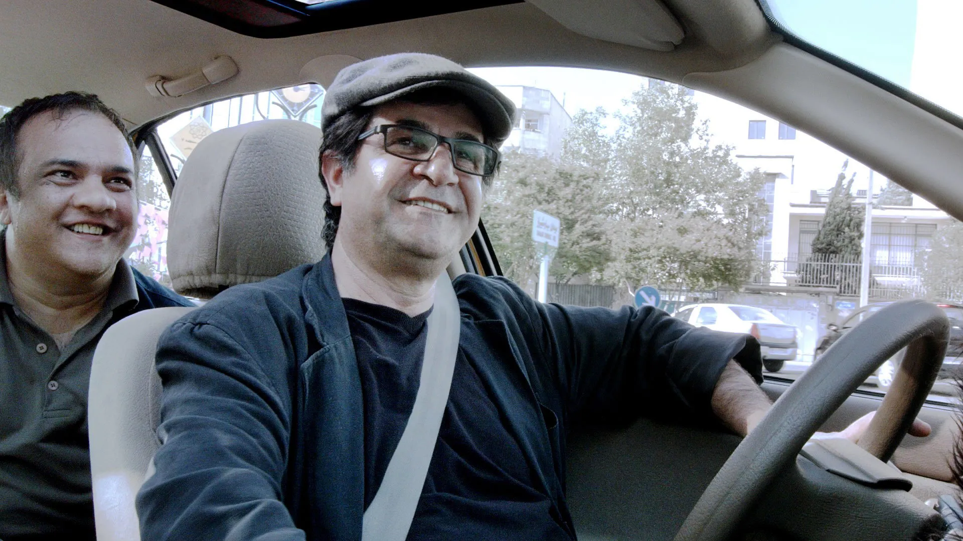 Smiling Despite the Disasters on the Road as the One Who Leads a Nation From One Side of the Road to the Other: Jafar Panahi’s Ongoing Role Beyond Film… His Taxi (2015)